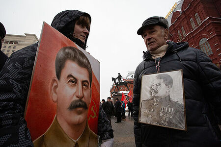 21.12.2022, Москва. Двое участников акции с портретами Слалина лруг напротив друга.