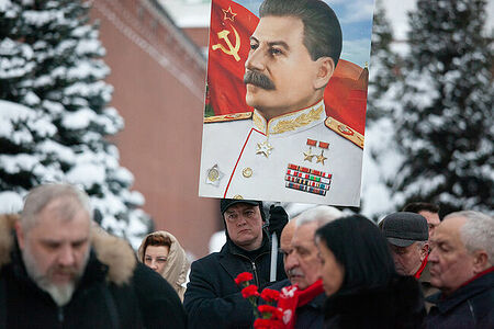 21.12.2022, Москва. Мужчина с портретом Иосифа Сталина во время акции по возложению цветов в день его дня рождения к его могиле у Кремлёвской стены.