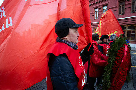21.01.2023, Москва. Мужчина с флагом КПРФ на шествии по случаю Дня памяти В. И. Ленина.