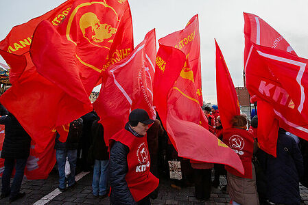 21.01.2023, Москва. Люди с красными флагами на Красной площади во время акции по случаю Дня памяти В. И. Ленина.