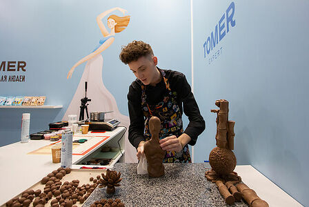 07.02.2023, Москва. Парень делает фигуры из шоколада на выставке «Продэкспо» 2023.