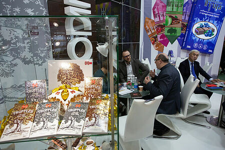 07.02.2023, Москва. Посетители что-то обсуждают на стенде производителя кондитерских изделий на выставке «Продэкспо» 2023.