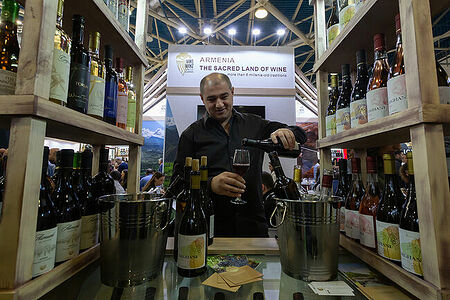 08.02.2023, Москва. Мужчина наливает вино в бокал на стенде армянского производителя вина на выставке «Продэкспо» 2023.