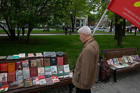 01.05.2023, Москва. Встреча депутатов фракции КПРФ с избирателями в формате патриотического митинга возле памятника Карлу Марксу. Мужчина рассматривает книги, которые продают на месте митинга.