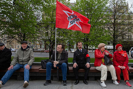 01.05.2023, Москва. Встреча депутатов фракции КПРФ с избирателями в формате патриотического митинга возле памятника Карлу Марксу. Участники митинга сидят на скамейке.