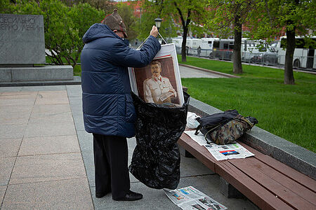 01.05.2023, Москва. Встреча депутатов фракции КПРФ с избирателями в формате патриотического митинга возле памятника Карлу Марксу. Мужчина-участник митинга упаковывает портрет Иосифа Сталина в пакет.