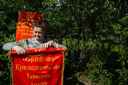 09.05.2023, Москва, Парк Горького, День Победы. Женщина сворачивает военный вымпел 6-й гвардейской Краснознамённой Танковой армии.