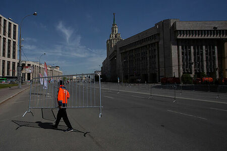 13.05.2023, Москва, Проспект Академика Сахарова. Рабочий убирает ограждение с дороги после массового мероприятия.
