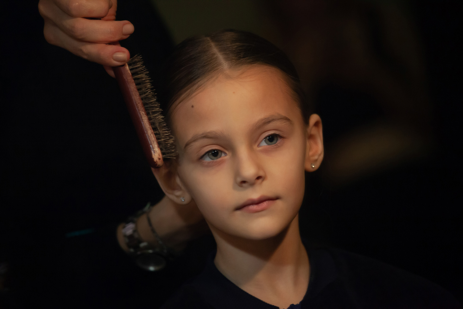 24.11.2022, Москва. Финал МКММ «Московского Конкурса Молодых Модельеров» в Театре «Школа современной пьесы». Маленькая девочка в гримёрке делает причёску и макияж перед выходом на подиум.