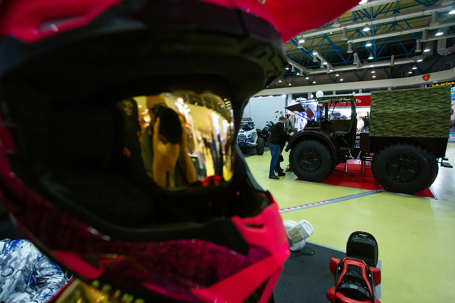 02.12.2022, Москва, Выставка, посвященная путешествиям и технике. «Поехали 2022» в Экспоцентре. Посетитель рассматривает автомобиль-вездеход.