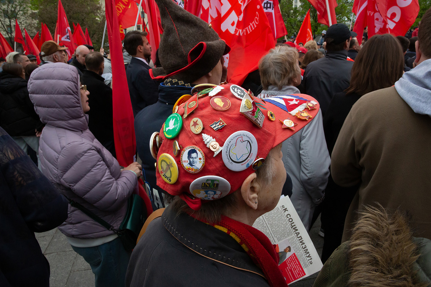 01.05.2023, Москва. Встреча депутатов фракции КПРФ с избирателями в формате патриотического митинга возле памятника Карлу Марксу. Женщина в кепке с приколотыми к ней значками.