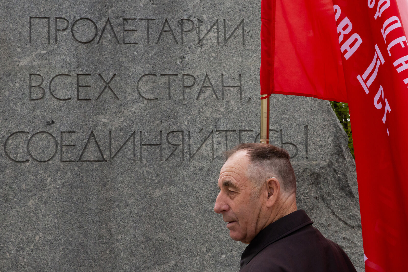 Встреча депутатов фракции КПРФ с избирателями в формате патриотического митинга возле памятника Карлу Марксу. Мужчина с флагом у памятника Карлу Марксу.